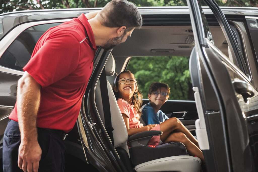 SP+ empleado de aparcacoches sonriendo a los niños en el coche