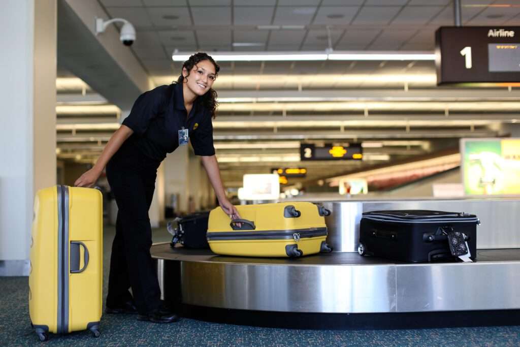 BAGs employee collecting luggage at baggage claim