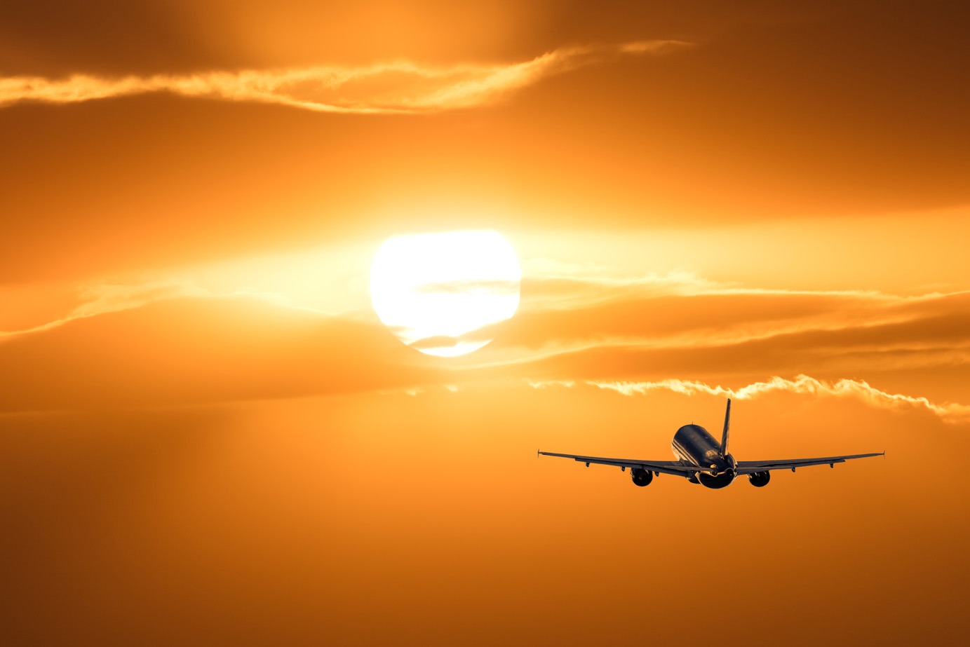 Avion s'envolant vers le coucher du soleil