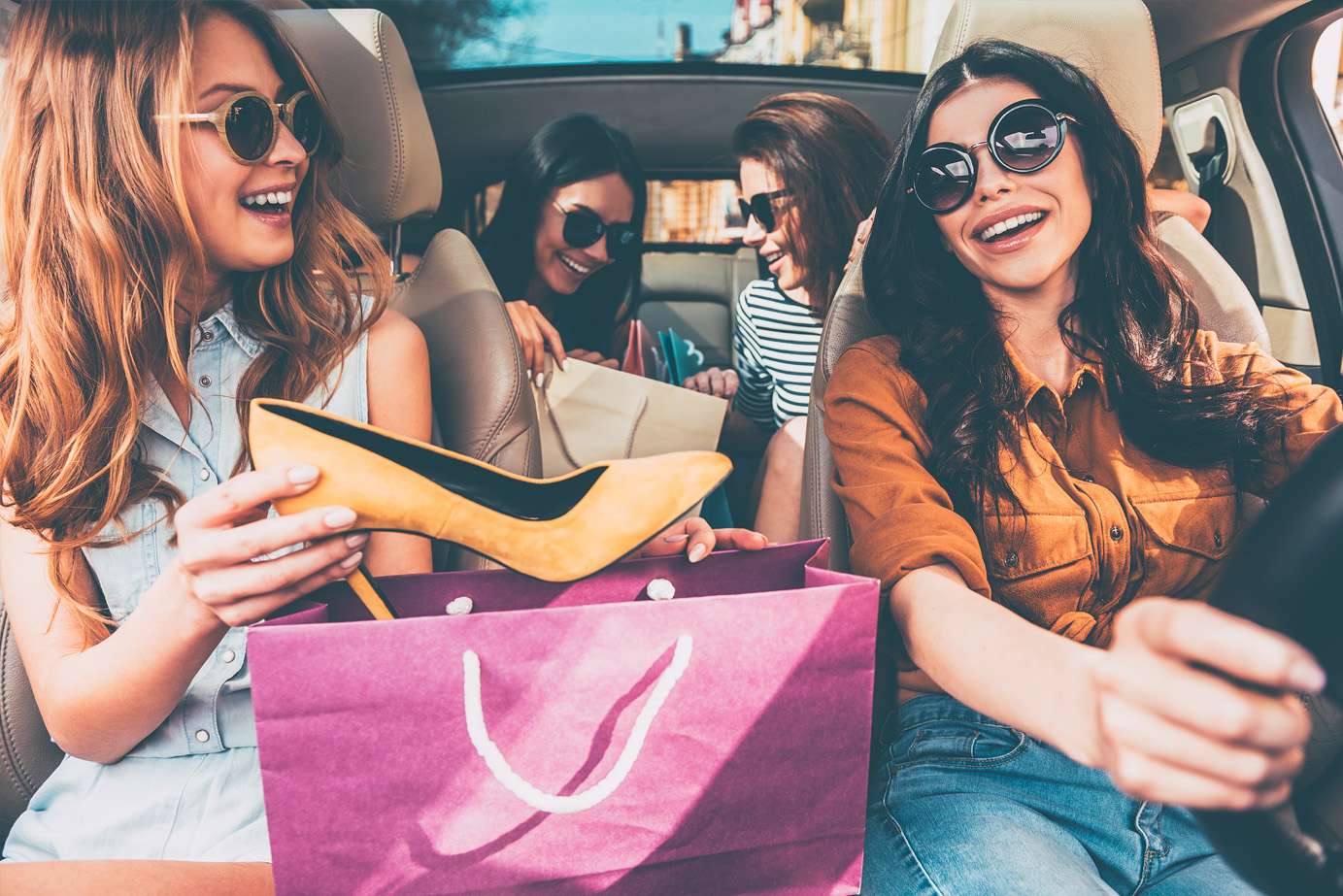 chicas en un coche con bolsas de la compra